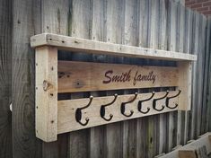 a wooden shelf with hooks hanging from it's sides and the words south family on it