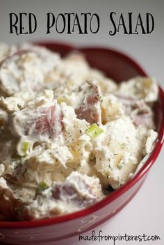 a red bowl filled with potato salad on top of a table