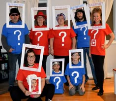 a group of people wearing costumes with question marks on them and one man holding a photo frame