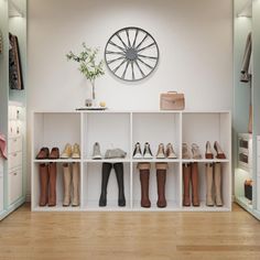 there are many pairs of shoes on the shelves in this room with a clock above them