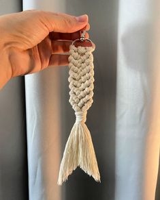 a person is holding up a white tassel