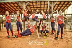 a group of young women standing on top of a dirt field holding baseball bats and ball