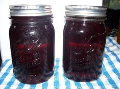 two mason jars sitting on top of a blue and white checkered table cloth