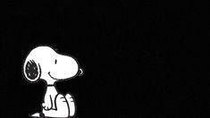 a black and white image of a snoopy dog sitting on the ground at night