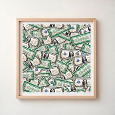 a wooden frame with money in it on a white wall above a framed photograph that is hanging on the wall