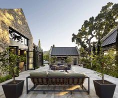 an outdoor seating area with potted plants and trees