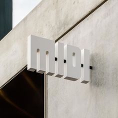 an open door to a building with white letters hanging from it's side wall