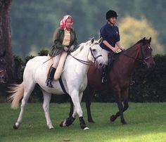 two people are riding horses in the grass