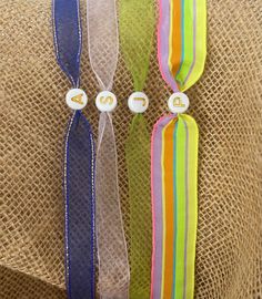 three different colored ribbons are tied together on a piece of burlocked material