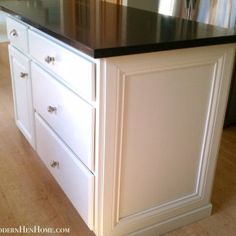 a white kitchen island with black counter top