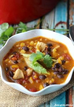 a white bowl filled with chicken taco soup and garnished with cilantro