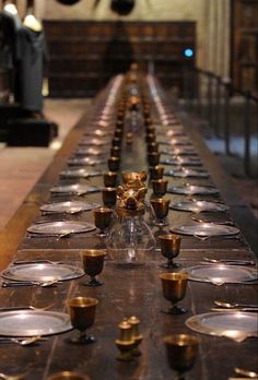 a long table with many empty plates and cups on it, along with an animal figurine in the center