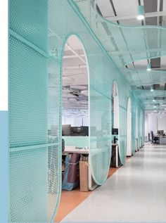 an office with blue mesh walls and white floors