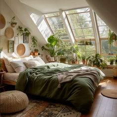 a bedroom with lots of plants in the windows and on the bed is a green comforter