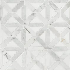 a white marble mosaic tile with an intricate design in the center and diagonals on each side