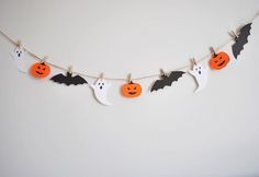 halloween decorations hanging on a clothes line with bats and pumpkins