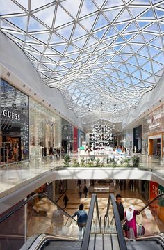 an escalator in a shopping mall with people walking around