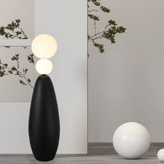 three white and black vases sitting next to each other on the floor in front of a wall