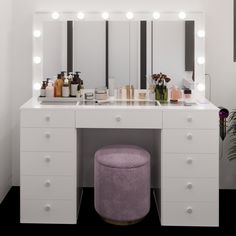 a white vanity with lights on it and a stool