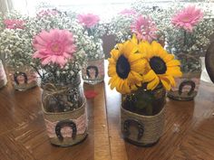 sunflowers and baby's breath in mason jars on a table with other flowers