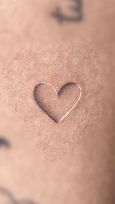 a small heart tattoo on the chest