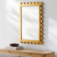 a mirror sitting on top of a wooden dresser