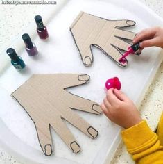 a child is cutting out paper with scissors and glues on the table next to some crafting supplies