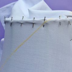 the sewing needle has been stitched into the fabric with yellow thread and is being sewn