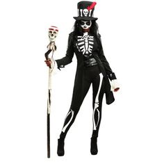 a woman dressed in black and white holding a skeleton stick while wearing a top hat