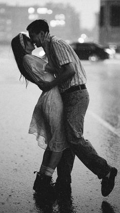 a man and woman kissing in the rain