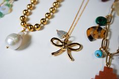 The cutest dainty bow necklace is here! The Coquette Bow necklace is made with a very delicate gold plated chain that has a bow and a shell heart charm. Necklace measures 17.5" long. Great to wear on its own or layer with other dainty necklaces Gold Butterfly Knot Necklace For Gift, Gold Necklaces With Butterfly Knot For Gift, Gold Necklace With Butterfly Knot For Gift, Gold Bow Necklace For Party, Gold Necklace With Bow For Party, Gold Bow Necklaces For Gifts, Gold Necklaces With Bow For Gifts, Gold Necklaces With Bow As Gifts, Gold Dainty Bow Jewelry