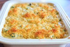 a casserole dish with broccoli and cheese in it on a table