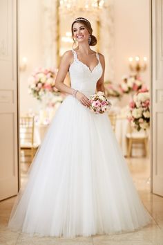 a woman in a white wedding dress posing for the camera