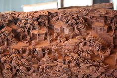 an intricately carved piece of wood with people and animals