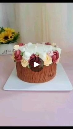 a cake that is sitting on top of a white plate and has flowers in it