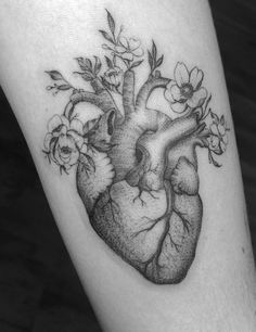 a black and white photo of a heart with flowers on it's side thigh