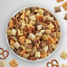 a bowl filled with cheetos and pretzels on top of a white table