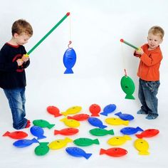 two young boys playing with plastic fish toys