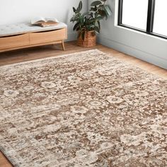 a large area rug in a room with wooden floors and white walls, along with a window