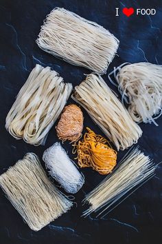 several different types of noodles laid out on a black surface with the words i love food written above them