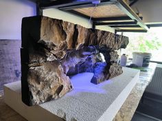 a large rock formation in the center of a room with lights on it's sides