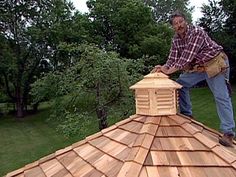 a man standing on top of a wooden roof