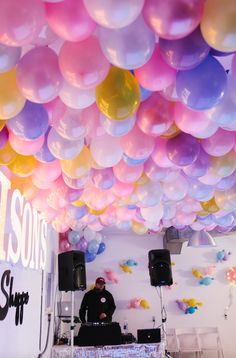 a dj is surrounded by balloons and streamers as he works on his turntable