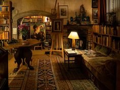 a living room filled with furniture and bookshelves next to a dog on the floor