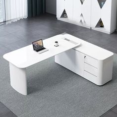 an office desk with a laptop on it in front of a white cabinet and rug