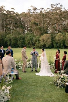 a bride and groom standing at the end of their wedding ceremony in front of an outdoor setting