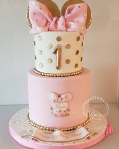 a pink and white cake with minnie mouse ears on top