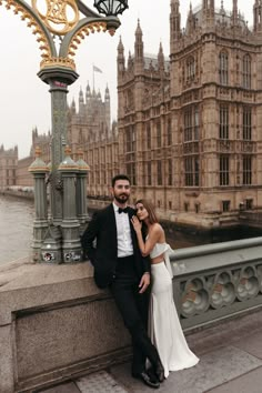 a man and woman standing next to each other in front of the big ben clock tower