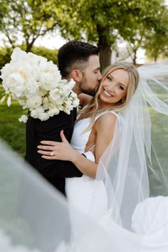 a bride and groom kissing under the veil