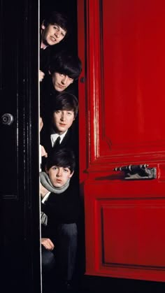 the beatles peeking out from behind a red door